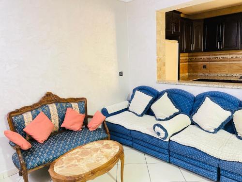 a living room with a blue couch and a chair at Laguna City Apartments in Nador