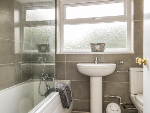 baño con lavabo y aseo y ventana en Wren's Nest en Thirsk