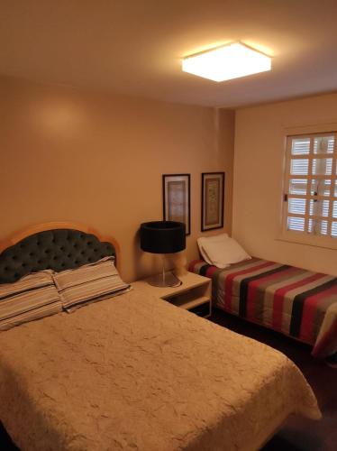 a bedroom with two beds and a window at Duplex em Gramado in Gramado