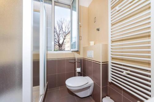 een badkamer met een toilet en een raam bij Sea Organ Apartment Zadar in Zadar