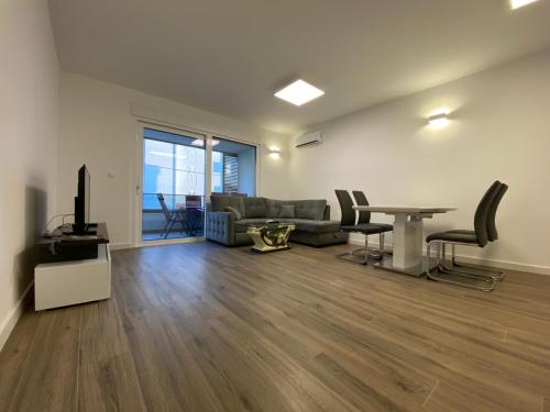 uma sala de estar com um sofá e uma mesa em Apartment Lida em Podstrana