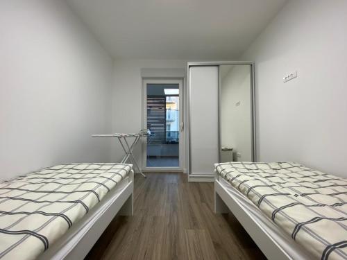 Duas camas sentadas num quarto com um espelho em Apartment Lida em Podstrana
