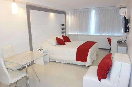 a hotel room with two beds and a table and chair at Hotel Gema Luxury Suites in Montevideo