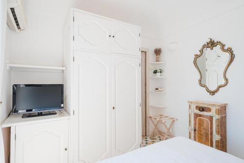 a bedroom with a white closet and a tv at Villa Giusy in Positano