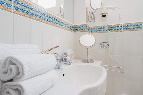 a white bathroom with a sink and a mirror at Villa Giusy in Positano
