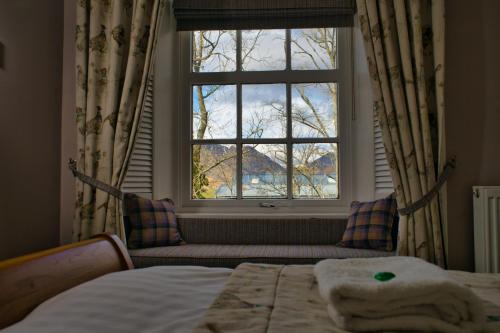 a bedroom with a window and a bed and a couch at Glen Clova Hotel & Luxury Lodges in Millton of Clova