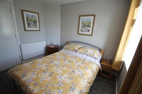 a bedroom with a bed and two pictures on the wall at Mullarts Church -The Glendun Apartment in Knocknacarry
