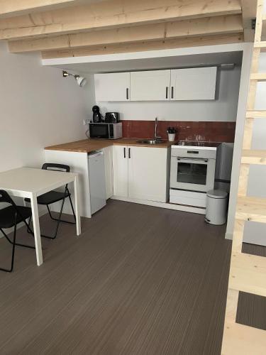 una pequeña cocina con armarios blancos y una mesa en duplex cosy au cœur de Royat, en Royat