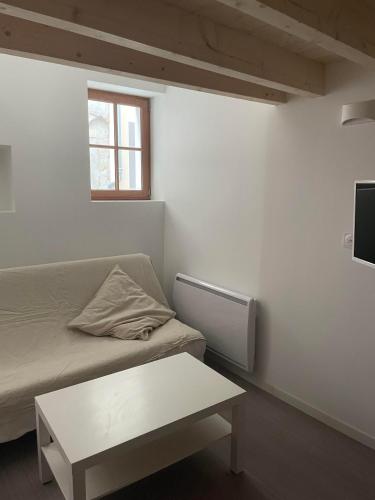 Cette petite chambre comprend un canapé et une table. dans l'établissement duplex cosy au cœur de Royat, à Royat