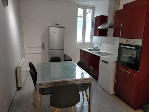 eine Küche mit einem Tisch und Stühlen sowie einem Kühlschrank in der Unterkunft Gîte Cœur d'Opale, seul hébergement 4 étoiles sur Étaples in Étaples
