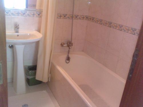 a bathroom with a bath tub and a sink at Residencial Nosso Paraiso in Quarteira