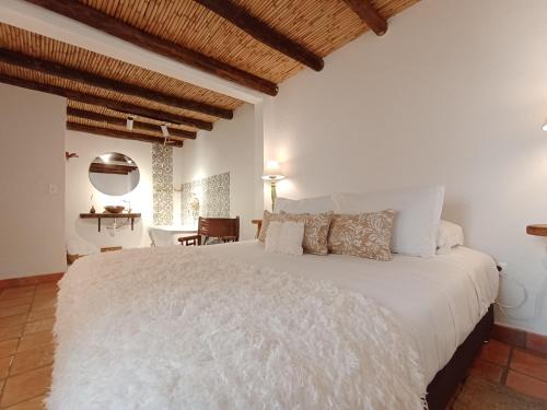 ein Schlafzimmer mit einem großen weißen Bett in einem Zimmer in der Unterkunft Hotel Casa Boutique Villa de Leyva in Villa de Leyva
