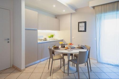 een keuken met een tafel en stoelen in een kamer bij Residenza Alma in Riccione