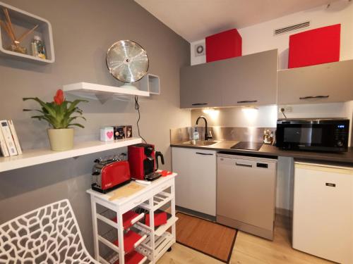 a kitchen with white cabinets and a counter top at Studio AppartHôtel OCEAN 7, Plage, Piscine, Terrasse in Biarritz