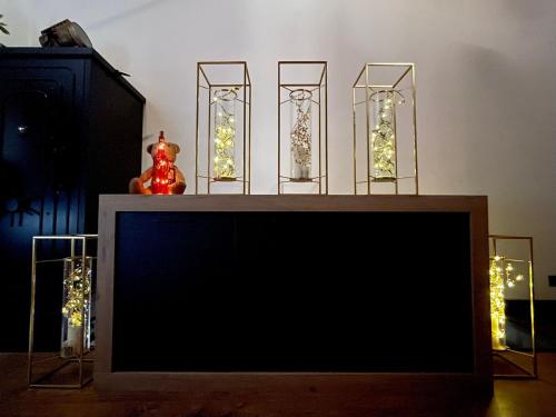 a tv screen with four glass vases with christmas lights at LA CASITA in Zamora