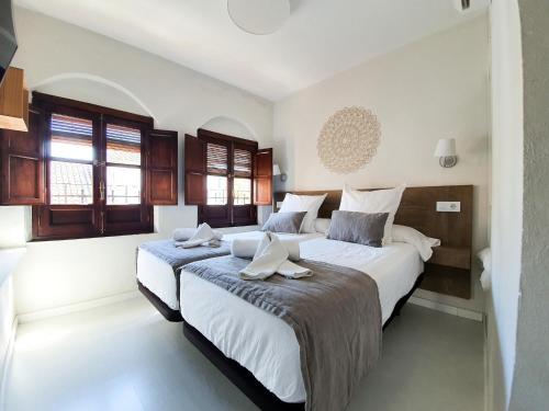 コルドバにあるCasa con Terraza San Fernandoのベッドルーム1室(ベッド2台、窓2つ付)