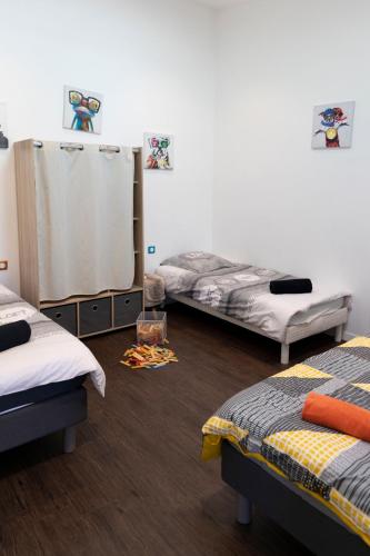 une chambre avec trois lits dans une pièce dans l'établissement Le Moulin de la Vollerie, à La Tourlandry