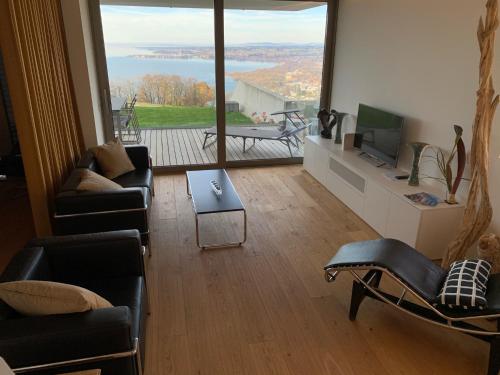 sala de estar con sofás, TV y balcón en Blickfang, en Lochau