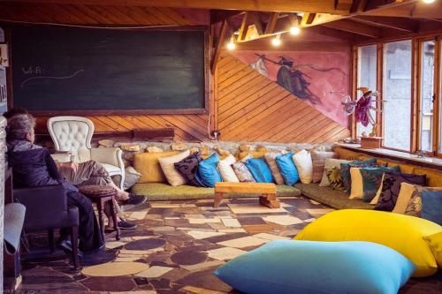 a living room with a couch and a chalkboard at Nomad Hostel in Nimrod