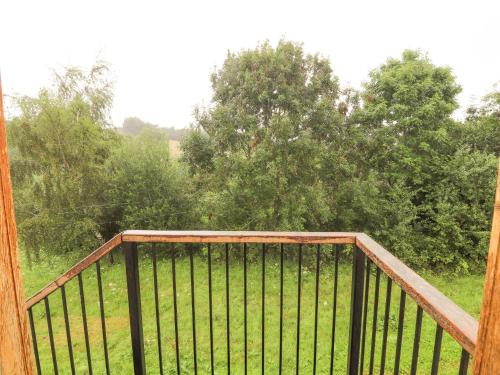 a balcony with a view of trees and grass at Ty Tabitha Wynne in Caerwys