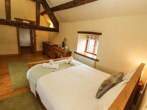 a bedroom with a large white bed and a window at Ty Tabitha Wynne in Caerwys