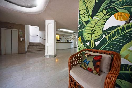 a wicker chair in a hallway with a mural at Emperador Vallarta Beachfront Hotel and Suites in Puerto Vallarta