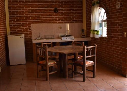 a kitchen with a wooden table and chairs and a refrigerator at Hotel y Cabañas Quinta Los Cipreses in Atlatlahucan