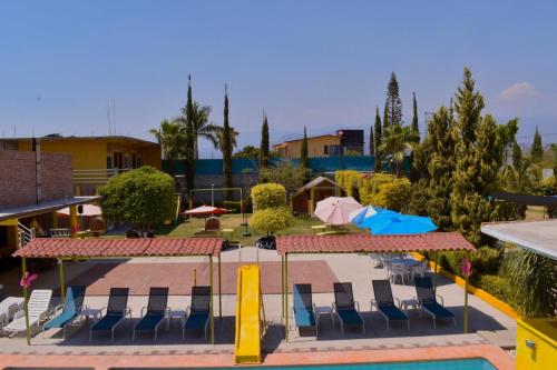 a pool with chairs and umbrellas at a resort at Hotel y Cabañas Quinta Los Cipreses in Atlatlahucan