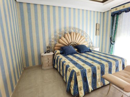 a bedroom with a bed with a blue striped wall at Aguamarina in Peñíscola