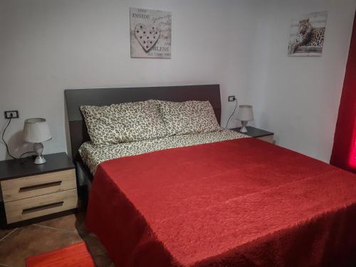 - une chambre avec un lit avec une couverture rouge et 2 lampes dans l'établissement Bon Bon, à Milis