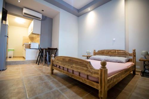a bedroom with a wooden bed and a kitchen at Kalamata home, Marina B in Kalamata