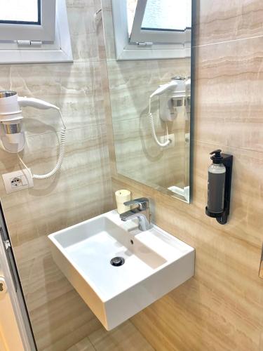 a bathroom with a white sink and a mirror at Hotel Aulona in Sarandë