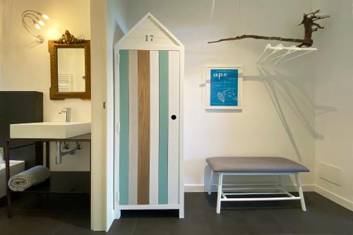a bathroom with a stool next to a sink at Pietraverdemare in Vallebona