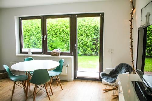 een woonkamer met een tafel en stoelen en een raam bij Ferienwohnung-Heinke-Urlaub-in-Tating-nahe-St-Peter-Ording in Tating