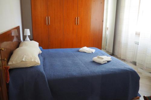 1 dormitorio con 2 toallas en una cama azul en Casa Morè Marina, en Carrara