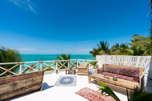 a patio with a couch and the ocean in the background at Casa Paradis Boutique Hotel in Jambiani