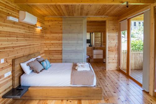 a bedroom with a bed in a wooden wall at Cabanas de Canduas in Cabana de Bergantiños
