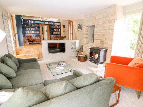 a living room with a couch and a fireplace at Under Catswood in Stroud
