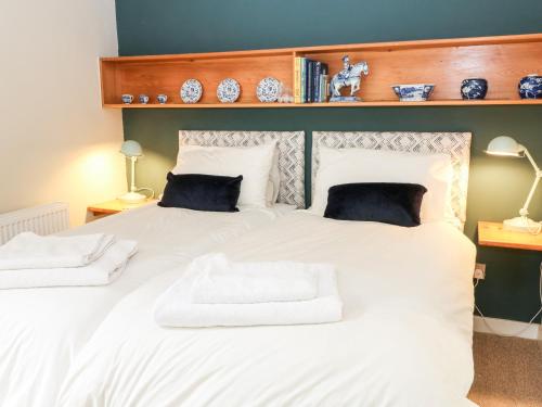 a bedroom with a large white bed with two pillows at Under Catswood in Stroud