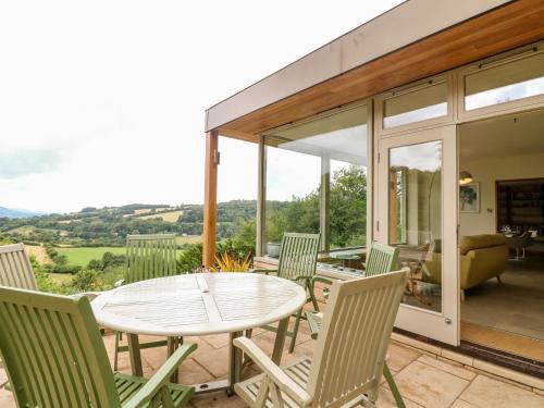 a patio with a white table and chairs at Under Catswood in Stroud