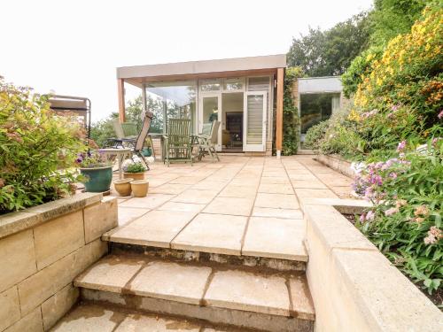 a patio with stairs leading to a house at Under Catswood in Stroud