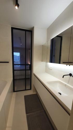 クノック・ヘイストにあるWalhalla Knokke sea viewの洗面台と鏡のある白いバスルーム