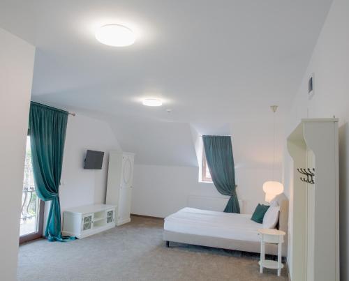 a room with a bed and a couch and a window at La Fontaine in Hunedoara