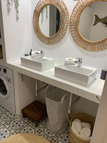 a bathroom with two sinks and two mirrors at Canyamel modern apartment pool & 360º roof-terrace in 3rd floor letter A in Canyamel