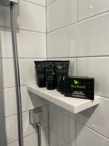a bathroom with a shelf with two products on it at The Maj Hotel in Philadelphia