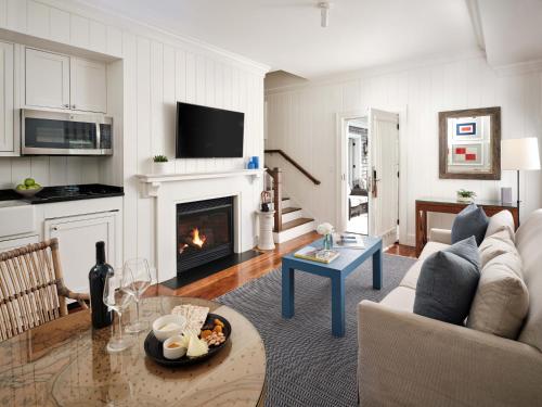 a living room with a couch and a fireplace at Harbor View Hotel in Edgartown