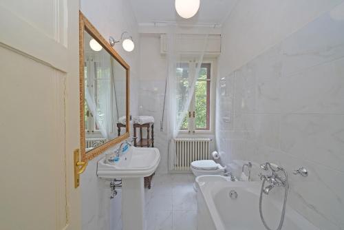 Un baño blanco con lavabo e inodoro. en Villa Maria, en Saló