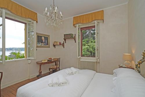 Un dormitorio con dos camas blancas y una ventana. en Villa Maria, en Saló