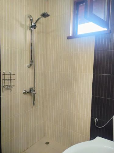 a bathroom with a shower with a toilet and a window at Holiday Home Veli in Sapareva Banya