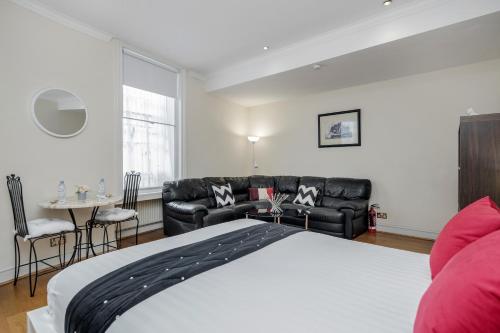 ロンドンにあるOxford Street Homestayのベッドルーム1室(ベッド1台、ソファ、テーブル付)